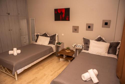 a room with two beds and a table with a bedskirts at Stylida Apartment - Ocean Air & Quiet Nights! in Stilís