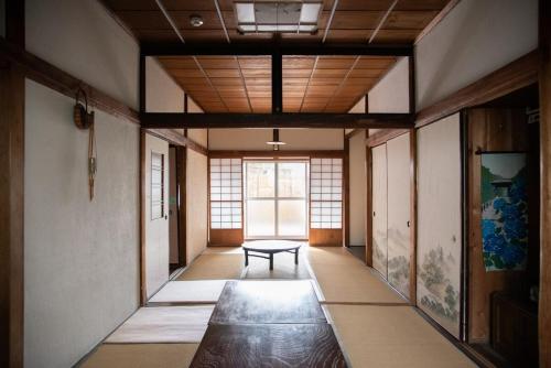 a room with a table and a bench in it at Tipy records inn house in Odawara
