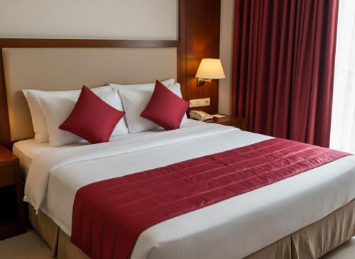 a large bed with red pillows in a hotel room at Munot residency in Manmād