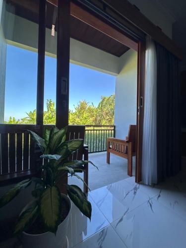 a porch with a potted plant in a room at MEDEWI BREEZE House in Airsatang