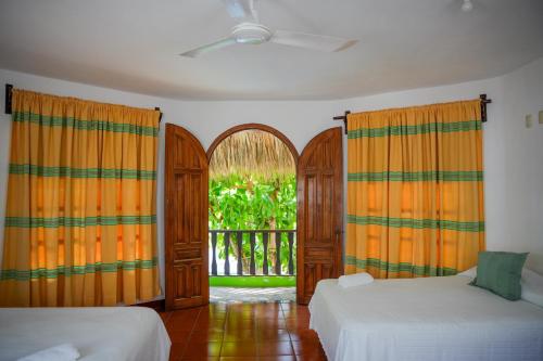 a bedroom with two beds and an open window at Bungalows Puerta de Sol in Brisas de Zicatela