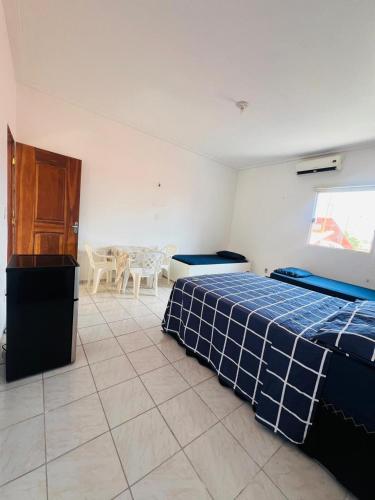 a bedroom with two beds and a table and chairs at Suíte com ampla área externa - Pink in São Luís