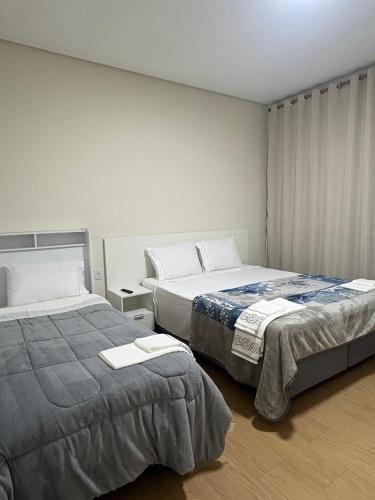 two beds in a small room withskirts at Pousada Diamante in Piranguçu