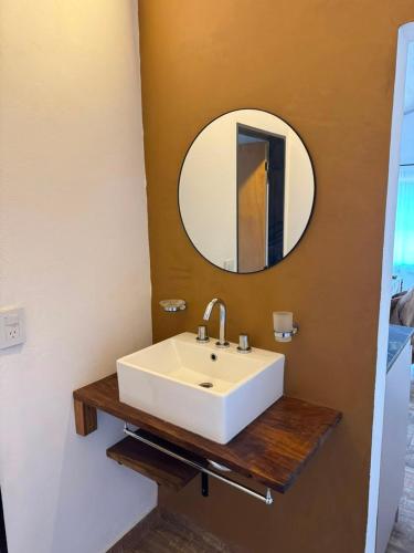 a bathroom with a white sink and a mirror at Crisálida Cabañas Villa Yacanto in Villa Yacanto