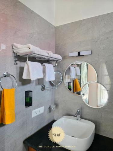 a bathroom with a sink and a mirror at The Jungle Hook Binsar in Almora