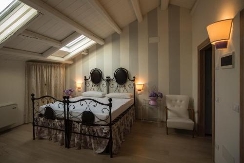 a bedroom with a bed and a chair at Dormire alla Ruota in Negrar