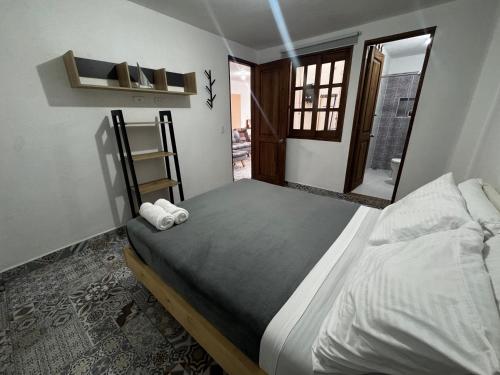 a bedroom with a bed with towels on it at Apartamento acogedor cerca al parque con balcón in Jardin