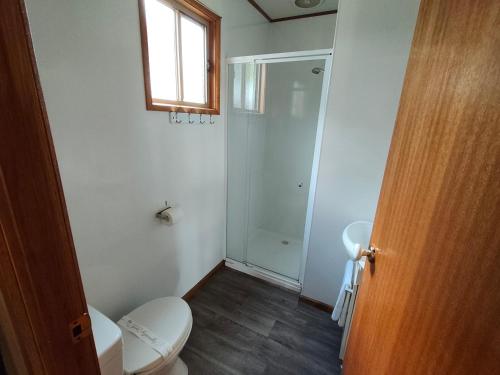 a bathroom with a toilet and a sink and a window at Highlander Van Village in Armidale