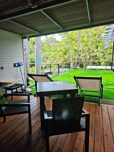 two tables and chairs on a wooden deck at Monkey House Hostel & Guest House Koh Samui in Chaweng Noi Beach