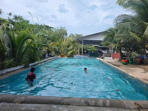 a man and a child in a swimming pool at Monkey House Hostel & Guest House Koh Samui in Chaweng Noi Beach