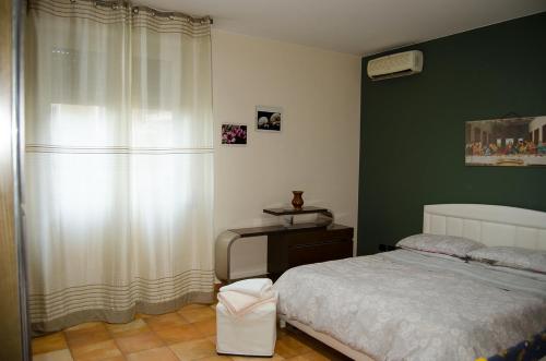 a bedroom with a bed and a desk and a window at House Etna View in Mascali