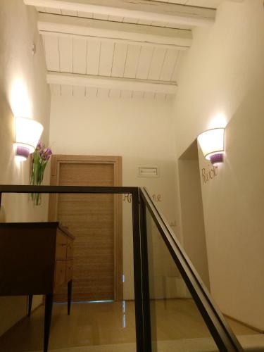 a staircase with two lights on the wall and a vase of flowers at Dormire alla Ruota in Negrar