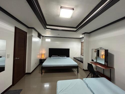 a bedroom with two beds and a table and a mirror at MG Holiday Home Tagaytay in Tagaytay