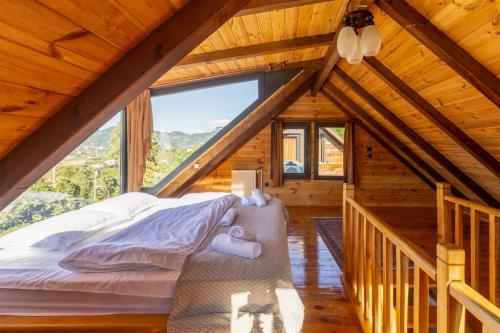 a bed in a room with a large window at Via Bungalows Batumi in Batumi