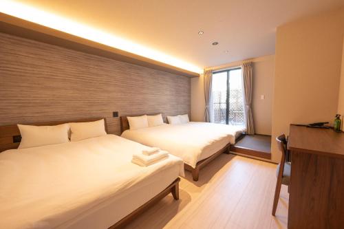 a hotel room with two beds and a window at WANOKAEDE HOTEL New Wing in Tokyo