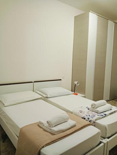 a room with three beds with towels on them at Aaron guest house 1 in Marghera