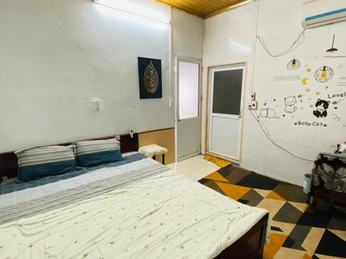 a bedroom with a bed and a wall with drawings on it at Nam Mỹ Vân Homestay - ĐH Công nghiệp Thái Nguyên in Thái Nguyên
