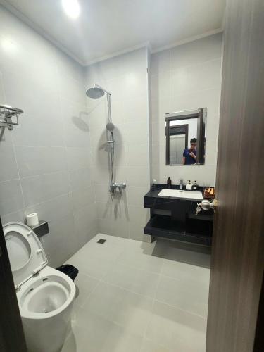 a bathroom with a toilet and a sink and a mirror at Sunrise Hotel Tại Sầm Sơn in Thanh Hóa