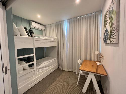 a small room with a bunk bed and a table at Eastern Blue Beachfront Apartment in Poste Lafayette