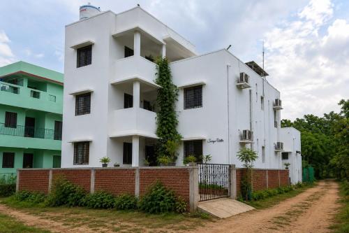 a white building with ivy growing on it at Surya Villa Guesthouse in Auroville
