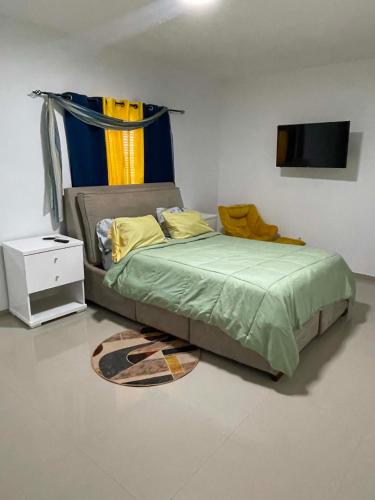 a bedroom with a bed with a television on the wall at Pinto’s in Praia