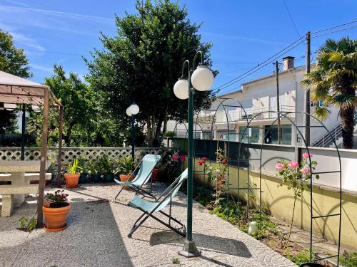 a chair and a light pole in a yard at Casa Palma Hostel in Barcelos