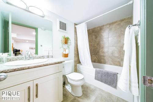 a white bathroom with a sink and a toilet at Spacious Bright Suite - Sleeps 4 - King Bed - NFLX in Edmonton