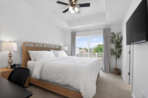 a white bedroom with a bed and a window at WYJEK Stays - Riverside Haven in Cambridge