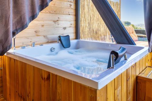 a jacuzzi tub in a log cabin at Via Bungalows Batumi in Batumi