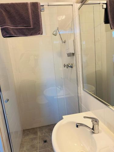 a bathroom with a sink and a shower at Bandicoot Motor Inn Hamilton in Hamilton