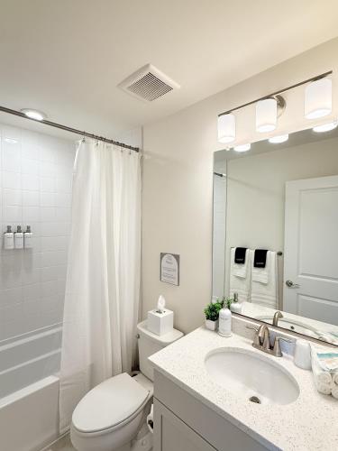 a white bathroom with a toilet and a sink at WYJEK Stays - Riverside Haven in Cambridge