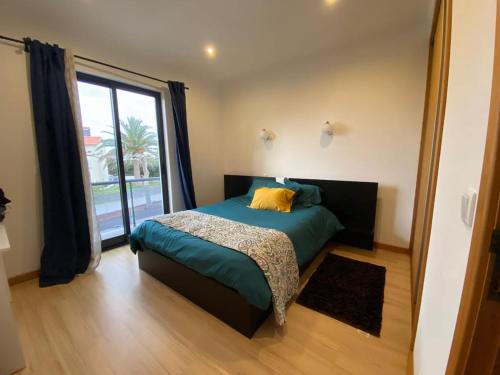 a bedroom with a bed and a large window at Maroiço Residence in Madalena