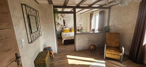 a room with a bedroom with a bed and a chair at Chez Denise in Eglingen