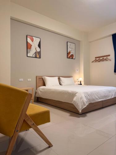 a bedroom with a large bed and a chair at 夏米旅宿 in Lukang