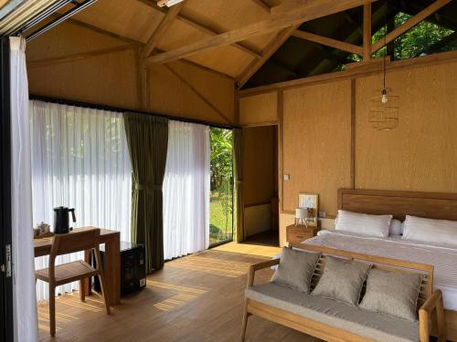 a bedroom with a bed and a table and a desk at Terra Clementia in Watukarung