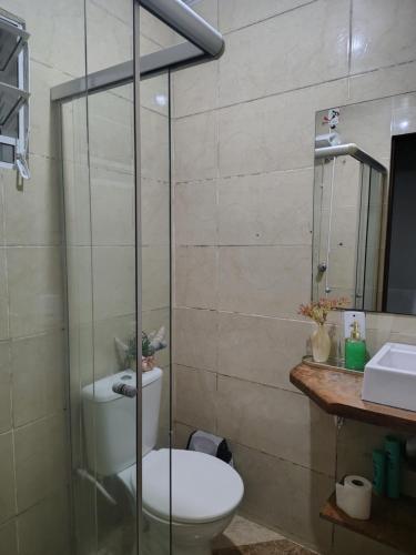 a bathroom with a toilet and a glass shower at Casa da Bebel in Uruguaiana