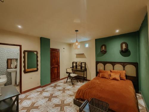 a bedroom with a bed with a green wall at Zu Suites in San Marcos La Laguna
