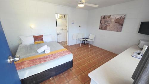 a bedroom with a bed and a table and a room at Sunburst Motel in Gold Coast
