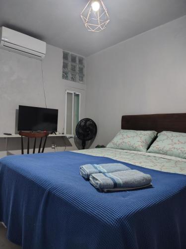 a bedroom with a blue bed with two towels on it at Casa da Bebel in Uruguaiana