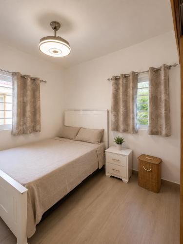 a bedroom with a large bed and two windows at My tropical home in La Laguna