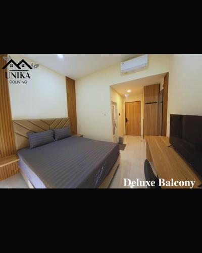 a bedroom with a bed and a television at Unika Coliving Vibes Syariah in Sultan Syarif Kasim II International Airport