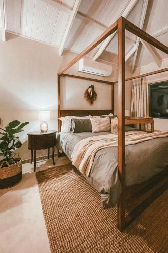 a bedroom with a canopy bed and a table at Lala Lodge in Hoedspruit