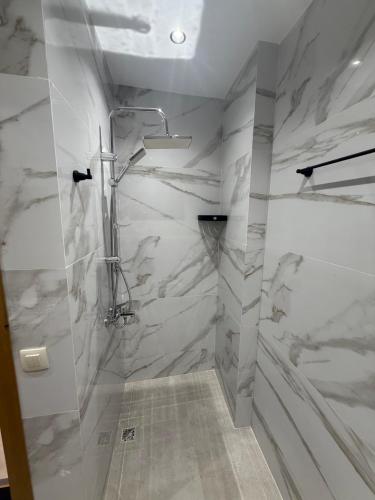 a bathroom with a shower with marble walls at اقامة هبة 5 in Yebha