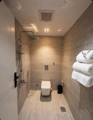 a bathroom with a toilet and a pile of towels at Bluestone Amlak 1 in Medina