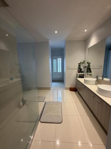 a large bathroom with two sinks and two mirrors at Sunnyhome in Truganina