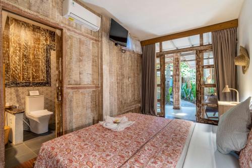 a bedroom with a bed with a flower on it at Ortigia Tropical Lodge in Gili Trawangan