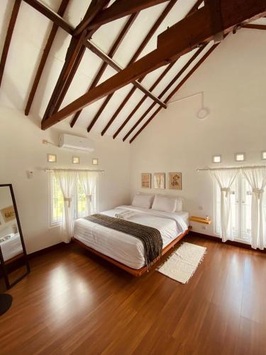 a large bedroom with a large bed and wooden floors at Spacious 3BR Villa Near Kaliurang - Arfani's House in Ngaglik