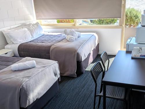 a hotel room with two beds and a table and chairs at The Swiss Motel in Cooma