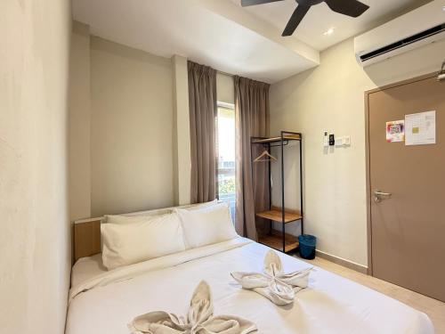 a bedroom with a white bed with flowers on it at Apex Hotel by Setapak Central in Kuala Lumpur