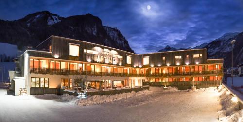 a building in the mountains with the moon in the sky at ACTIVE by Leitner's in Kaprun